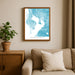 Framed map of Tampa Bay on a wall above a beige sofa with a plant beside it.