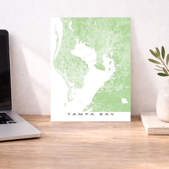 Map of Tampa Bay on a desk with a laptop and plant