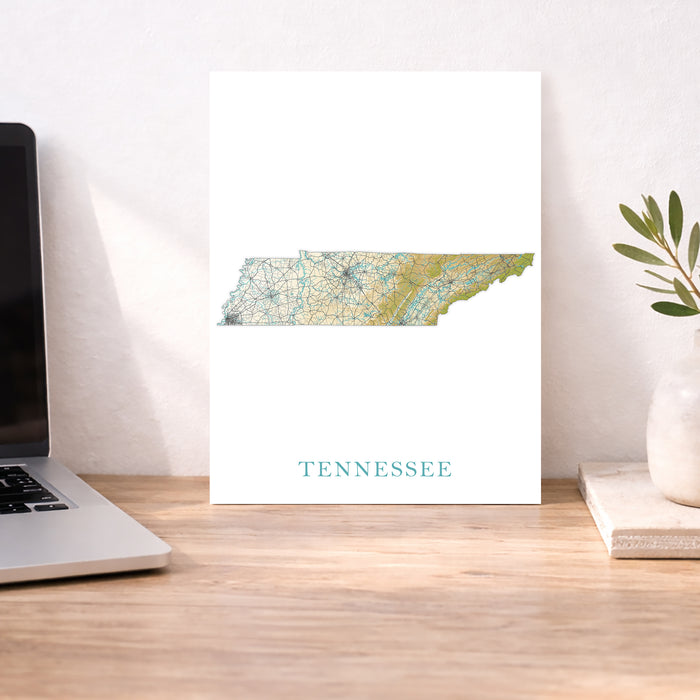 Map of Tennessee on a desk with a laptop and plant