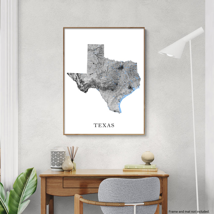 Framed map of Texas on a wall above a desk with decor items.