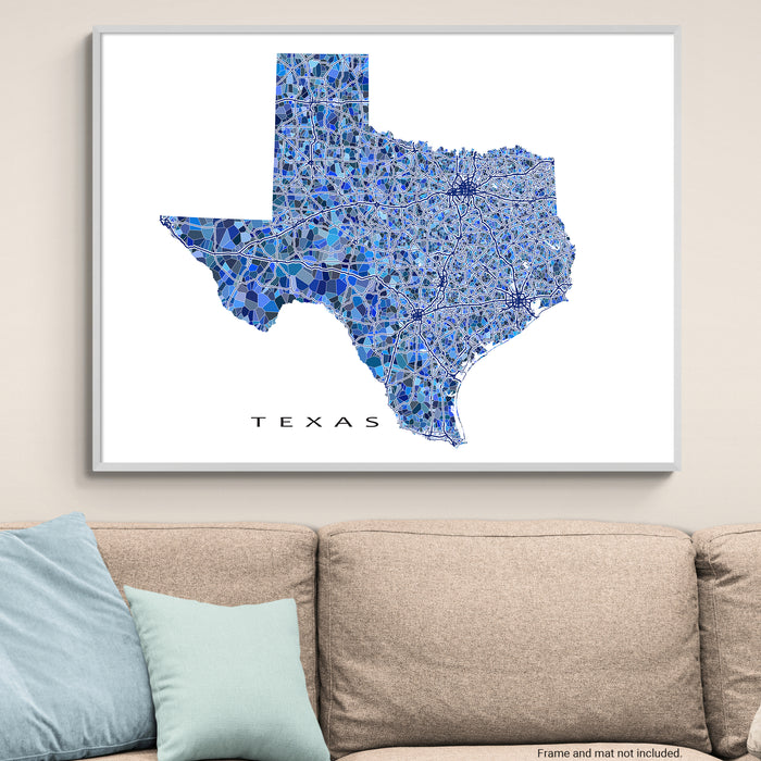 Framed map of Texas with blue mosaic pattern on a wall above a beige sofa.