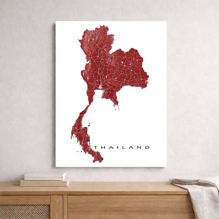 Map of Thailand on a white background, framed and leaning against a light gray wall.