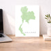 Map of Thailand on a white background next to a laptop on a wooden desk.