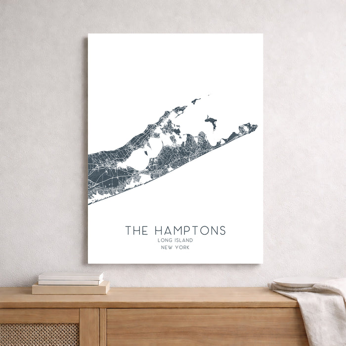 Map of The Hamptons, Long Island, New York on a white wall above a wooden shelf.