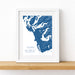 Framed map print of Tofino, Ucluelet, and Vancouver Island on a white wall.