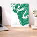 Map of Tofino and Ucluelet on a wall above a desk with a laptop and plant.