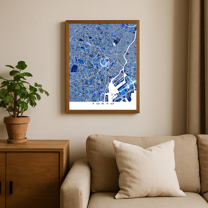 Framed map of Tokyo on a wall above a beige sofa with a plant beside it.