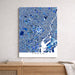 Map of Tokyo in blue and white on a wall above a wooden shelf.