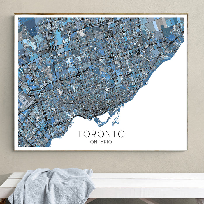 Framed map of Toronto, Ontario on a wall above a white surface.