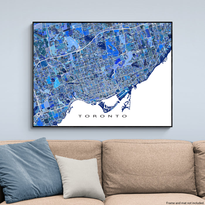 Framed map of Toronto on a wall above a beige sofa with decorative pillows.