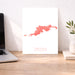 Map of Tortola on a white background next to a laptop on a wooden desk.