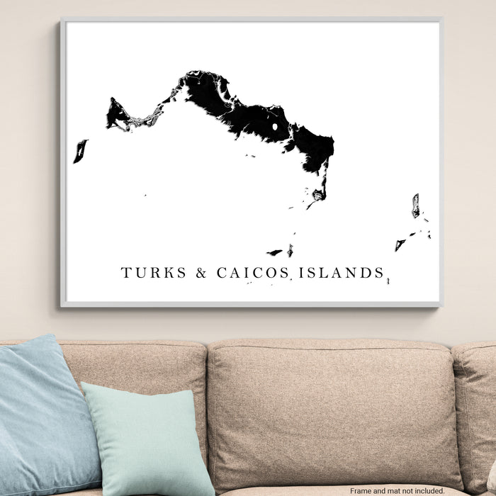 Framed map of Turks and Caicos Islands on a wall above a sofa.
