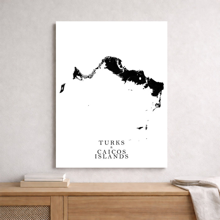 Map of Turks and Caicos Islands on a white wall above a wooden shelf.