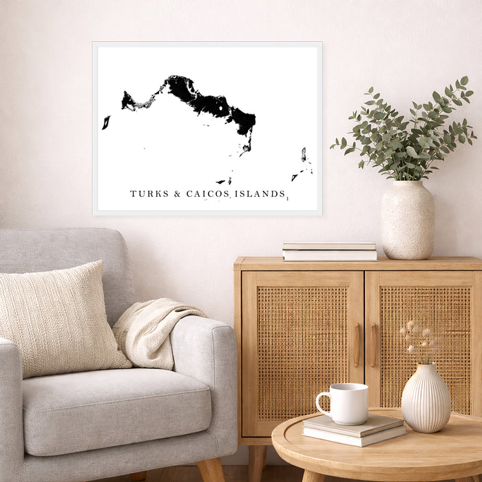 Living room with a map of Turks and Caicos Islands on the wall, a couch, and a side table with decor items.