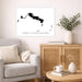 Living room with a map of Turks and Caicos Islands on the wall, a couch, and a side table with decor items.