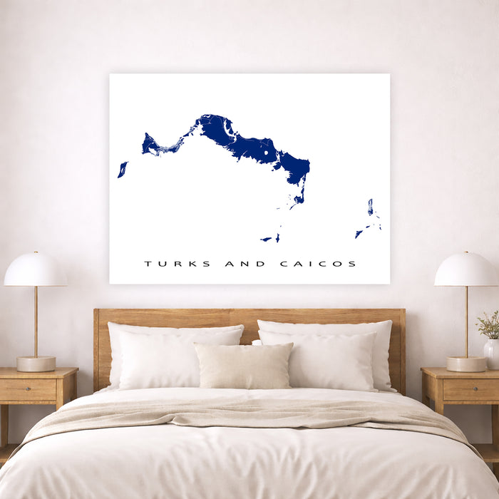 Map of Turks and Caicos on a wall above a bed in a bedroom.
