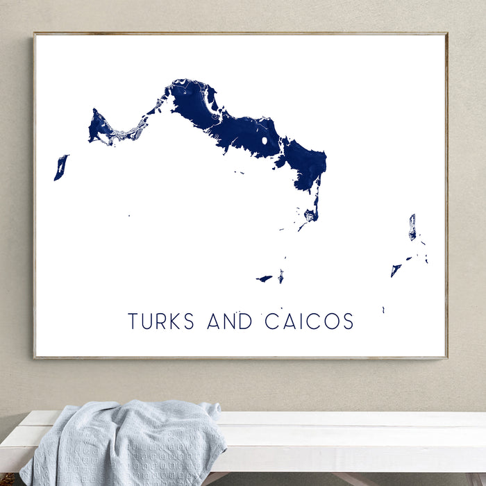 Framed map of Turks and Caicos on a wall above a white bench.