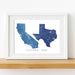 Framed map print of California and Texas on a white wall.