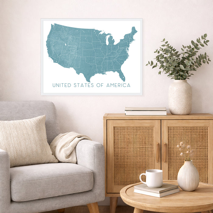 Living room with a map of the United States on the wall, a couch, and a wooden cabinet.