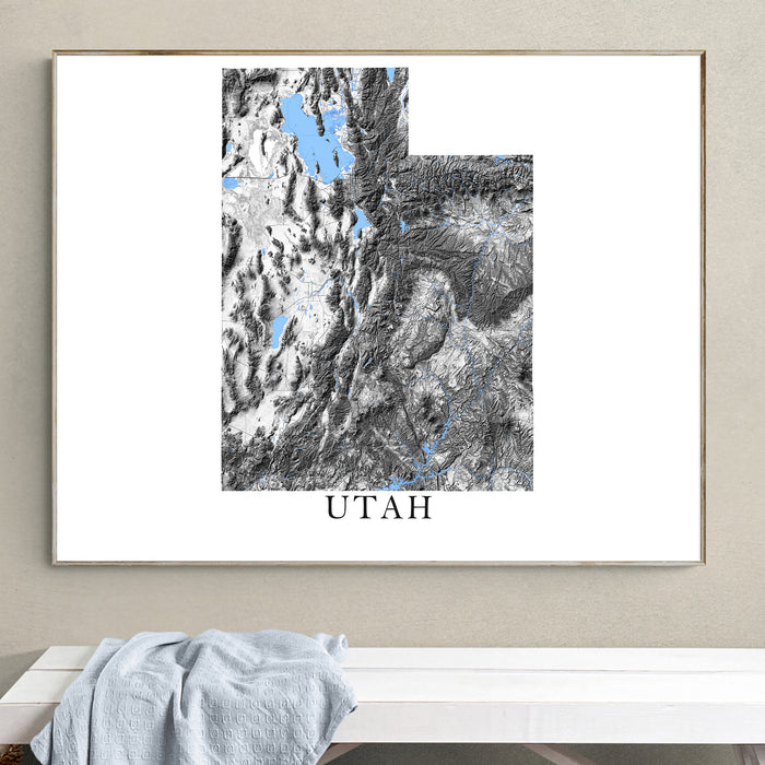 Framed map of Utah on a wall above a white bench.