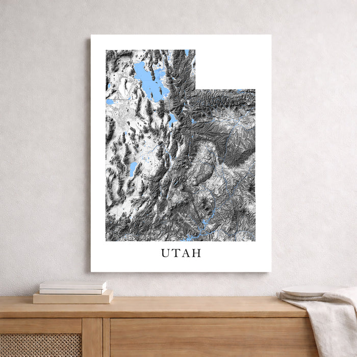 Framed map print of Utah on a wall above a wooden surface.