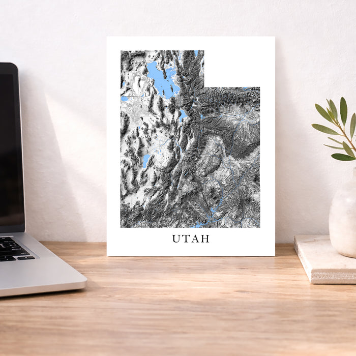 Map of Utah on a desk with a laptop and plant