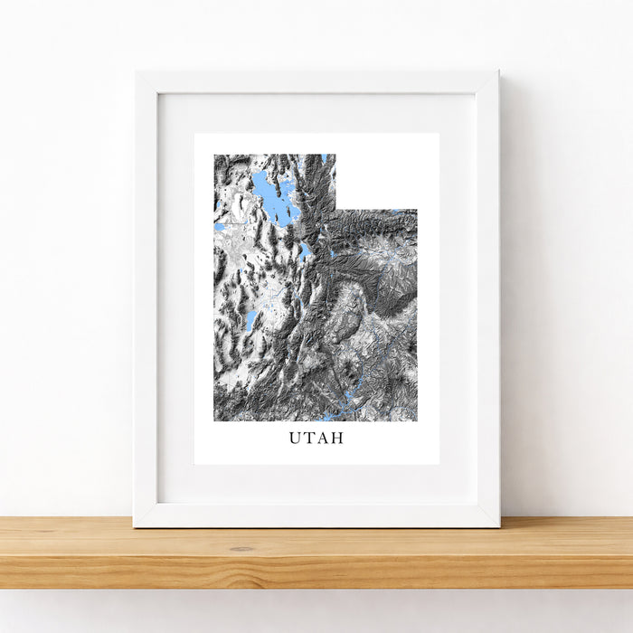 Framed map print of Utah on a wooden surface with a white background