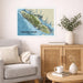 Living room with a map of Vancouver Island on the wall, a vase with plants, and a coffee table with books and a mug.