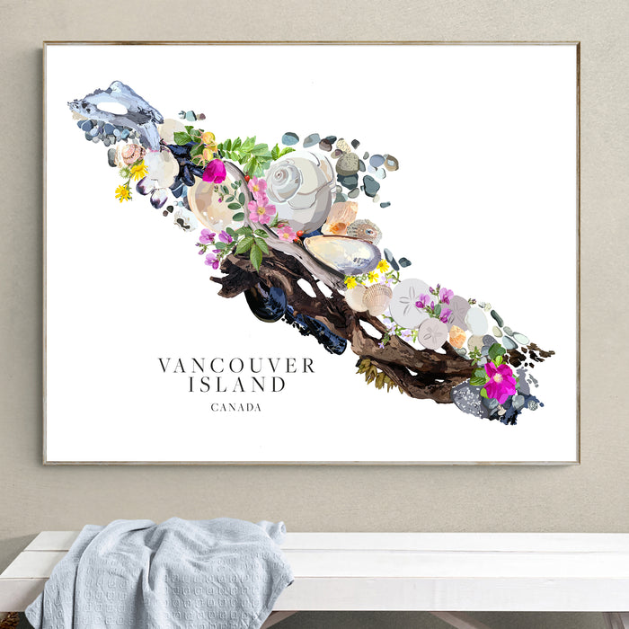 A framed art print of Vancouver Island, Canada, featuring a hand-drawn design of driftwood, seashells, and flowers on a white background, hanging on a light gray wall above a white bench with a blue-gray throw blanket.