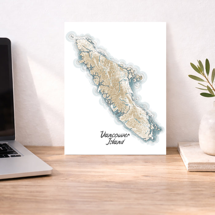 Map of Vancouver Island on a desk with a laptop and plant