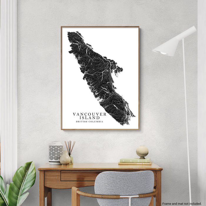 Framed map of Vancouver Island on a wall above a desk with decor items.