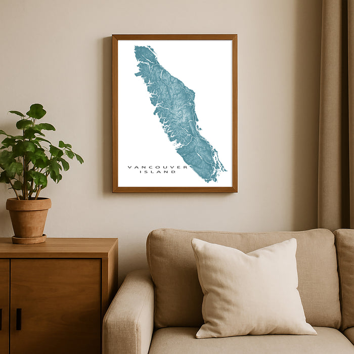 Framed map of Vancouver Island on a wall above a beige sofa with a plant beside it.