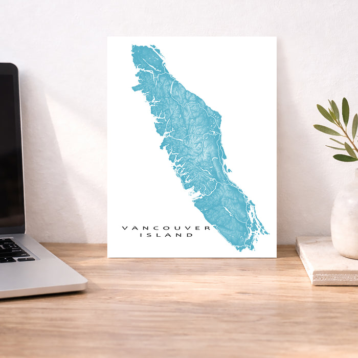 Map of Vancouver Island on a desk with a laptop and plant