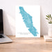 Map of Vancouver Island on a desk with a laptop and plant