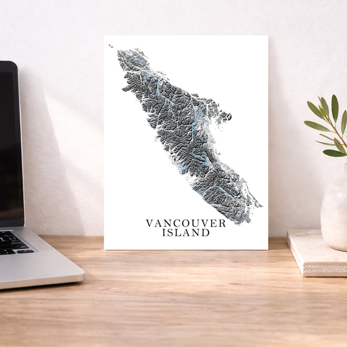Map of Vancouver Island on a desk with a laptop and plant