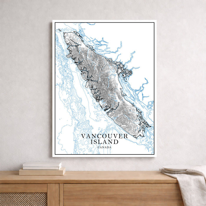 Framed map of Vancouver Island, Canada on a wall above a wooden surface.