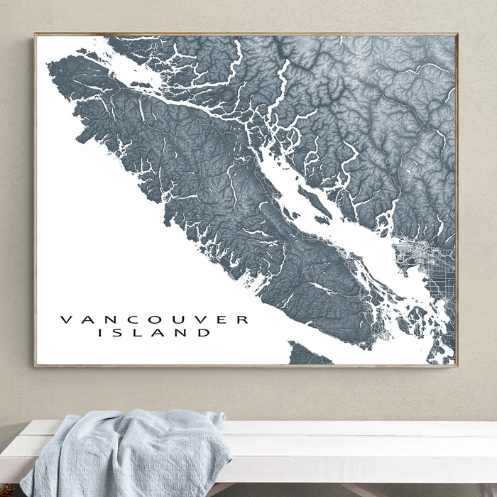 Framed map of Vancouver Island on a wall above a white surface.