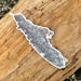 Map-shaped sticker on a wooden surface