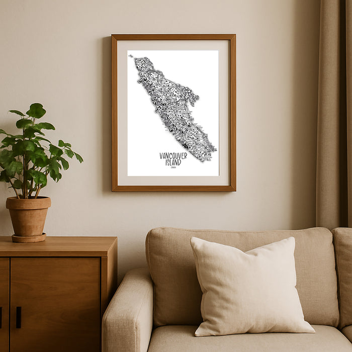 Framed map of Vancouver Island on a wall above a beige sofa with a plant beside it.