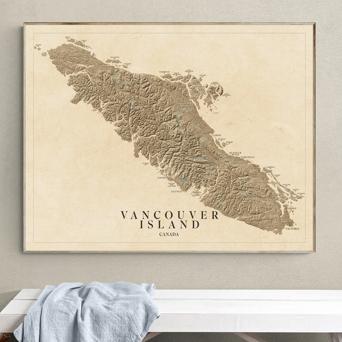 Framed map of Vancouver Island, Canada on a wall above a white surface.