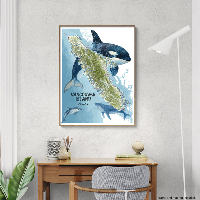 Framed map of Vancouver Island with orca whales on a wall above a desk.