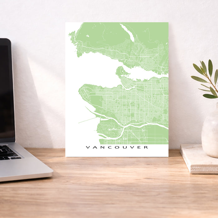 Map of Vancouver on a desk with a laptop and plant