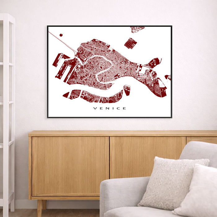 Framed map of Venice on a wall above a wooden cabinet and white sofa.