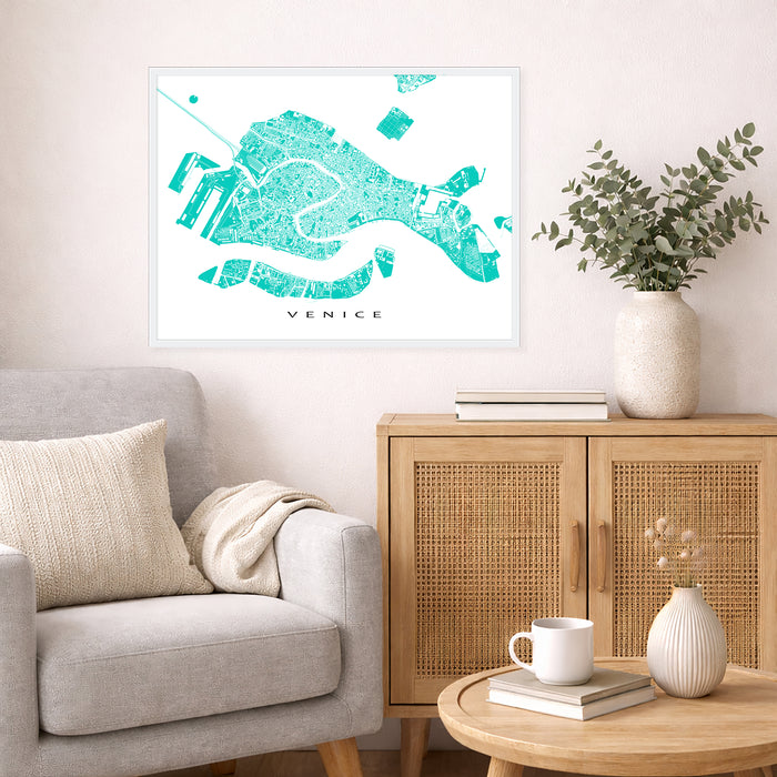 Living room with a map of Venice on the wall, a couch, and a side table with a plant and books.