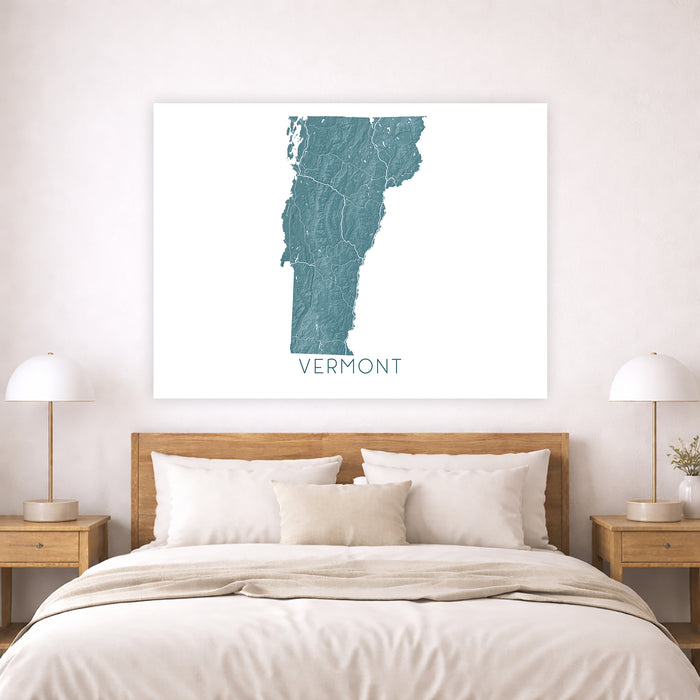 Map of Vermont on a wall above a bed in a bedroom setting