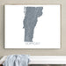 Framed map of Vermont on a wall above a white bench.