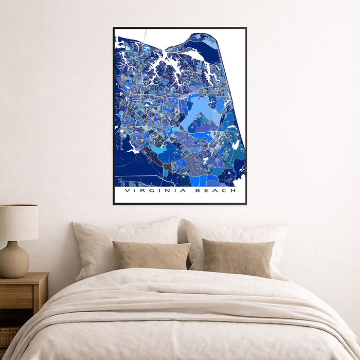 Framed map of Virginia Beach on a wall above a bed.