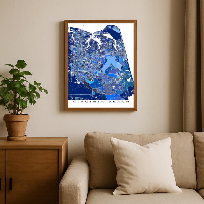 Framed map of Virginia Beach on a wall above a beige sofa with a plant beside it.