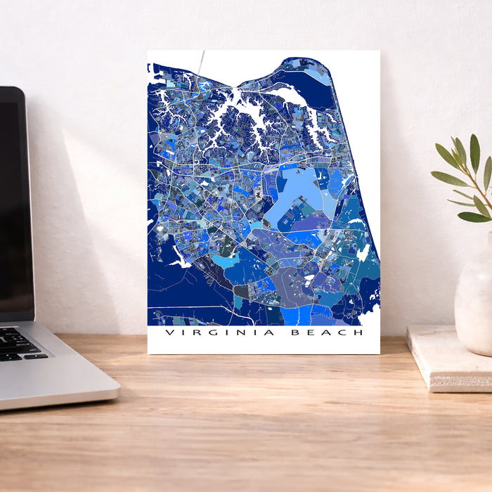Map of Virginia Beach on a desk with a laptop and plant