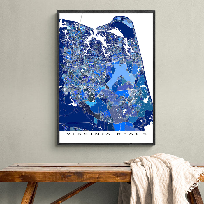 Framed map of Virginia Beach on a wall above a wooden bench.